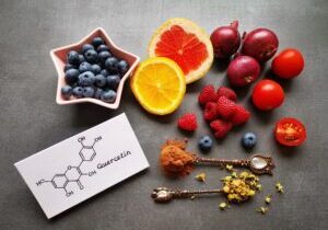 Structural chemical formula of quercetin molecule with fresh fruit and vegetable. Quercetin is a plant pigment (flavonoid). It's found in many plants and foods such as red onions, berries, tomatoes...